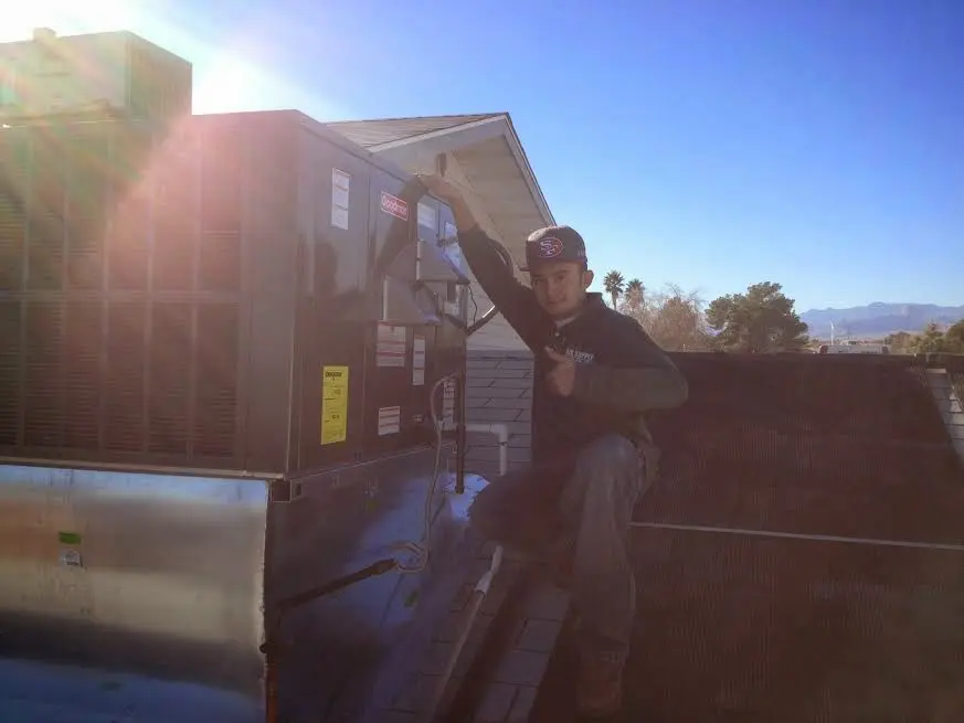 HVAC technician performing HVAC Inspection on a rooftop unit in Los Alamos